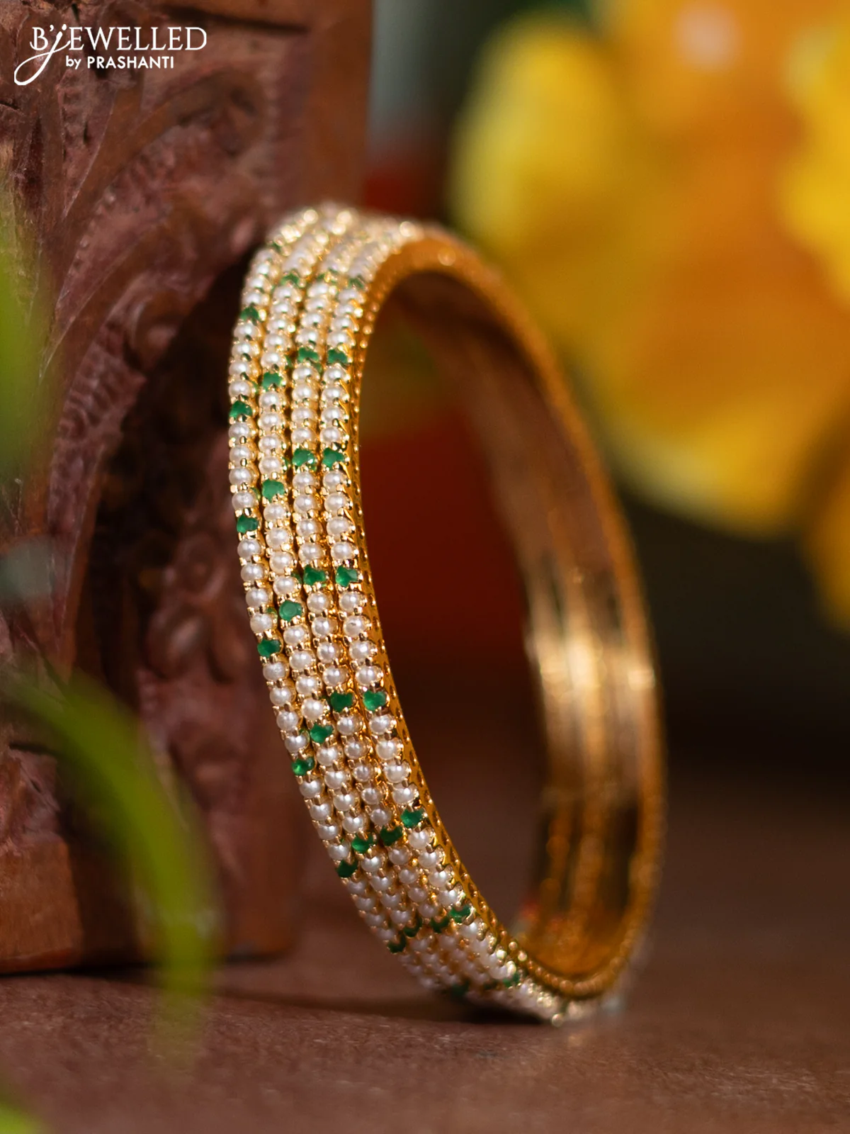 Pearl bangle with emerald stones and pearls in gold finish