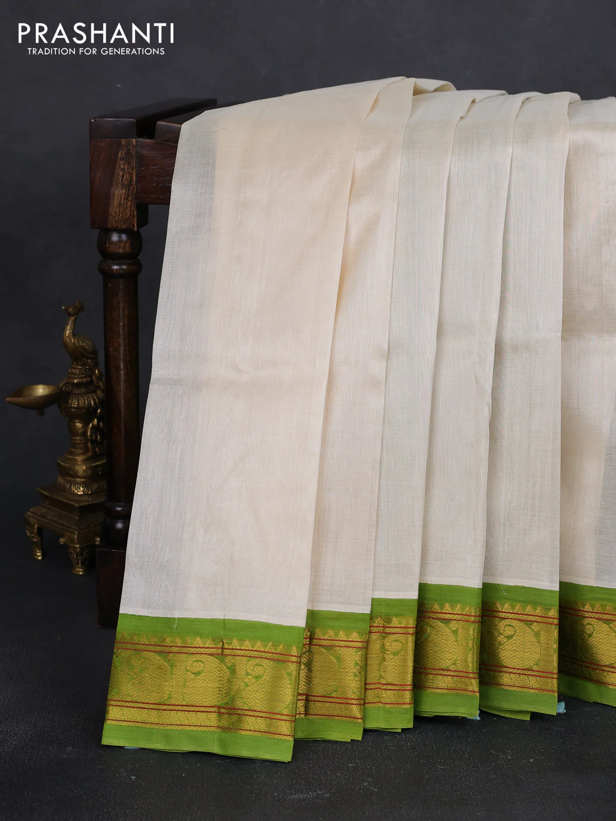 Silk cotton saree cream and light green with plain body and paisley zari woven korvai border